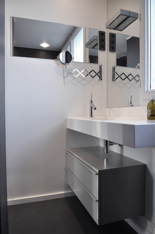 Inspiration för ett litet funkis badrum med dusch, med grå skåp, en öppen dusch, grå kakel, vita väggar, ett avlångt handfat, bänkskiva i akrylsten, släta luckor och klinkergolv i keramik