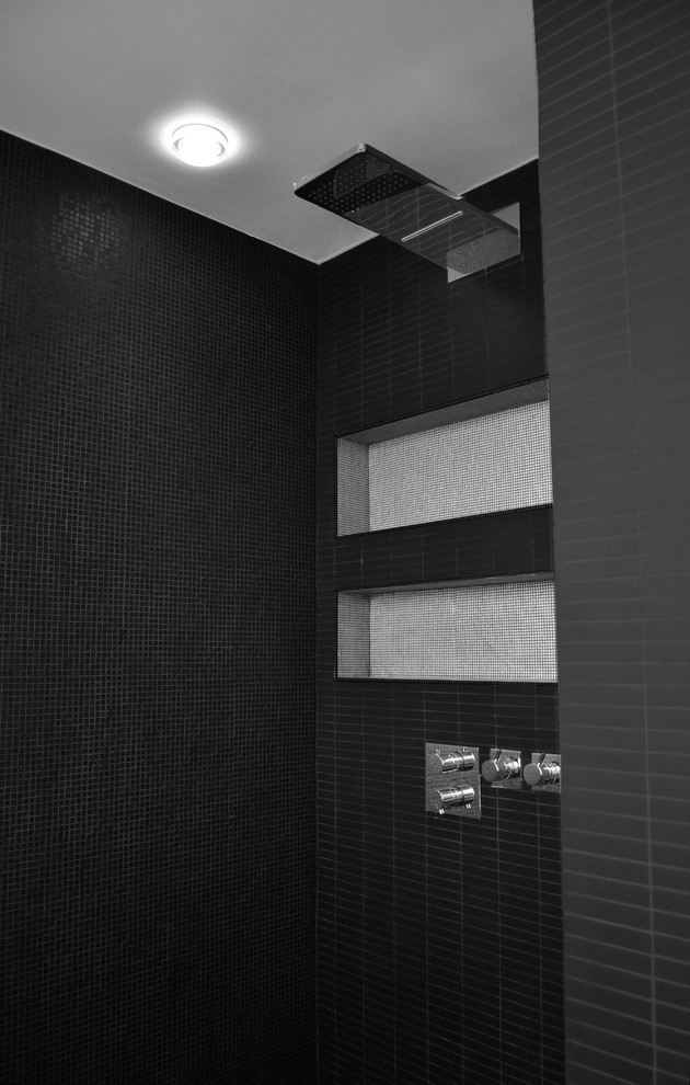 Inspiration pour une petite salle d'eau design avec des portes de placard grises, une douche ouverte, un carrelage gris, un mur noir, un sol en carrelage de céramique, une grande vasque et un plan de toilette en surface solide.