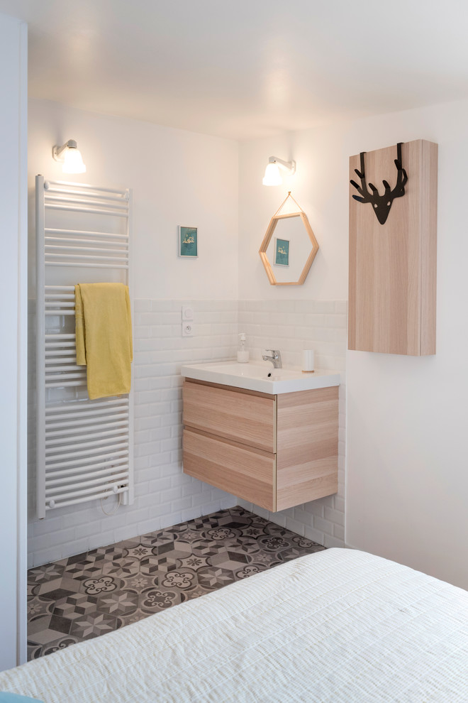 Inspiration for a small scandinavian shower room bathroom in Lyon with beaded cabinets, light wood cabinets, an alcove shower, white tiles, metro tiles, white walls, laminate floors, a built-in sink, granite worktops, beige floors and white worktops.