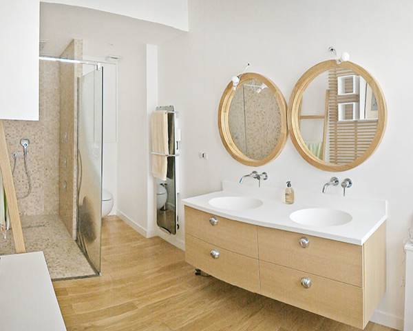 Modern inredning av ett stort en-suite badrum, med luckor med profilerade fronter, skåp i ljust trä, en kantlös dusch, en vägghängd toalettstol, beige kakel, mosaik, vita väggar, ljust trägolv, ett konsol handfat och bänkskiva i akrylsten