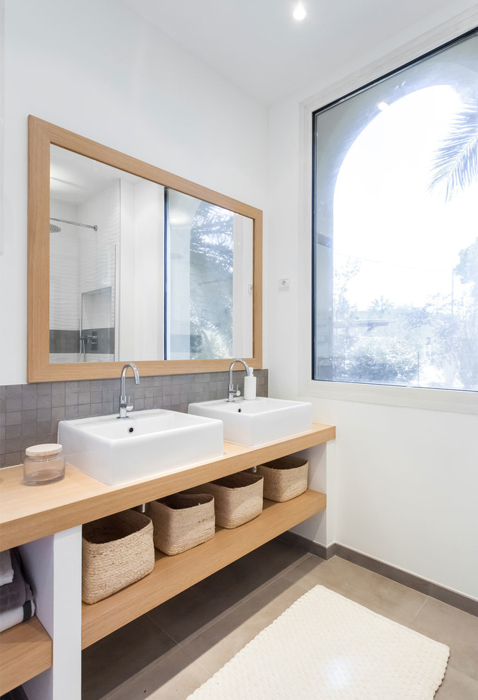 Inredning av ett nordiskt stort en-suite badrum, med skåp i ljust trä, en kantlös dusch, vit kakel, mosaik, vita väggar, klinkergolv i keramik, ett nedsänkt handfat, träbänkskiva och grått golv
