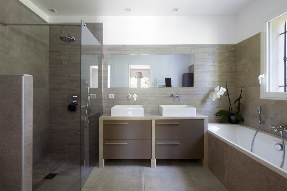 Пример оригинального дизайна: ванная комната в современном стиле с полновстраиваемой ванной, душем без бортиков, бежевыми стенами, настольной раковиной и бежевым полом