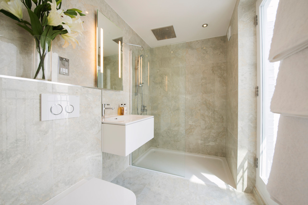 Inredning av ett modernt mellanstort vit vitt badrum med dusch, med släta luckor, vita skåp, en dusch i en alkov, en vägghängd toalettstol, beige väggar, ett integrerad handfat och beiget golv