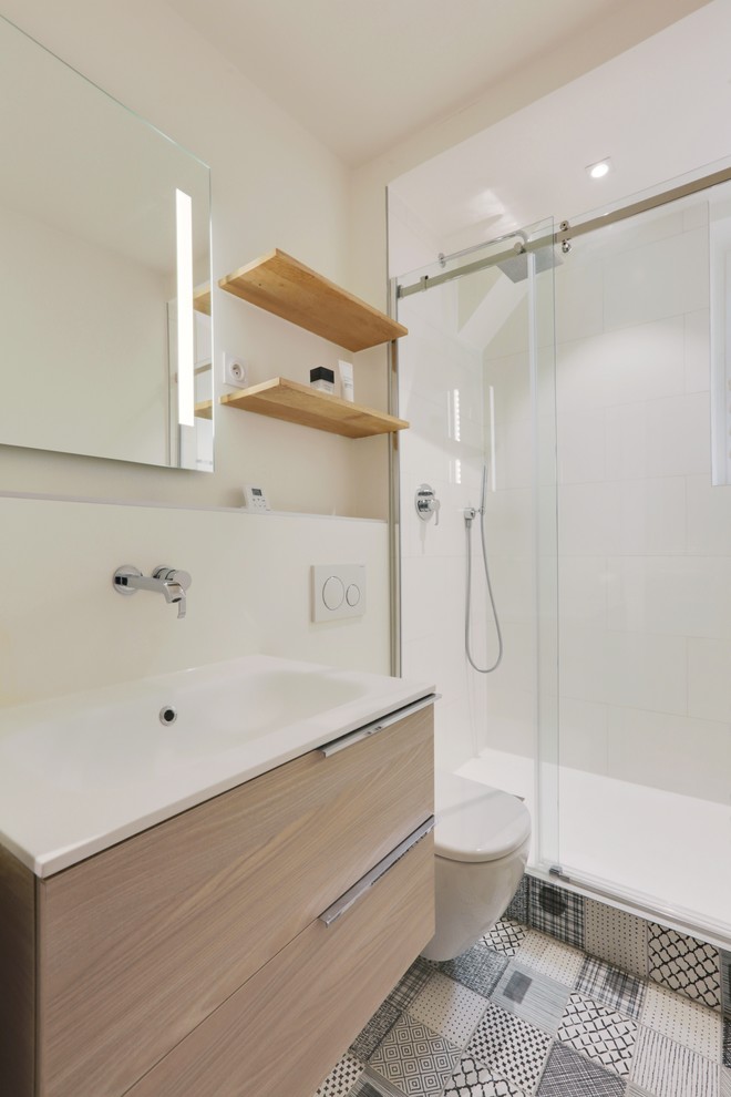 Idéer för ett litet minimalistiskt badrum med dusch, med skåp i ljust trä, en kantlös dusch, en vägghängd toalettstol, vit kakel, svart och vit kakel, keramikplattor, vita väggar, klinkergolv i keramik, ett konsol handfat och bänkskiva i akrylsten