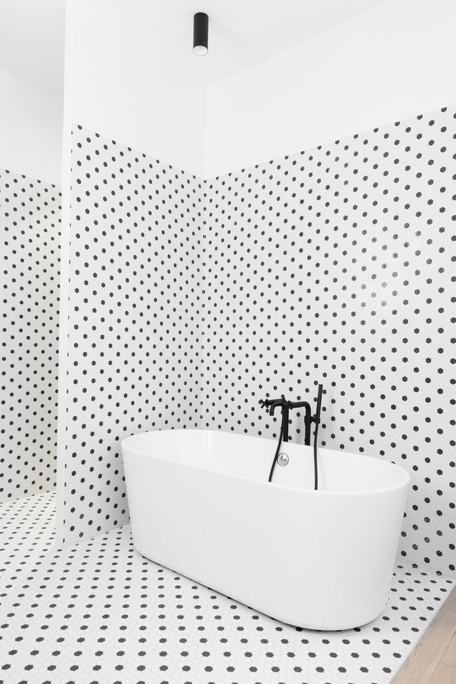 Exemple d'une salle de bain principale tendance avec une baignoire indépendante, une douche ouverte, un carrelage noir et blanc, un mur multicolore et aucune cabine.