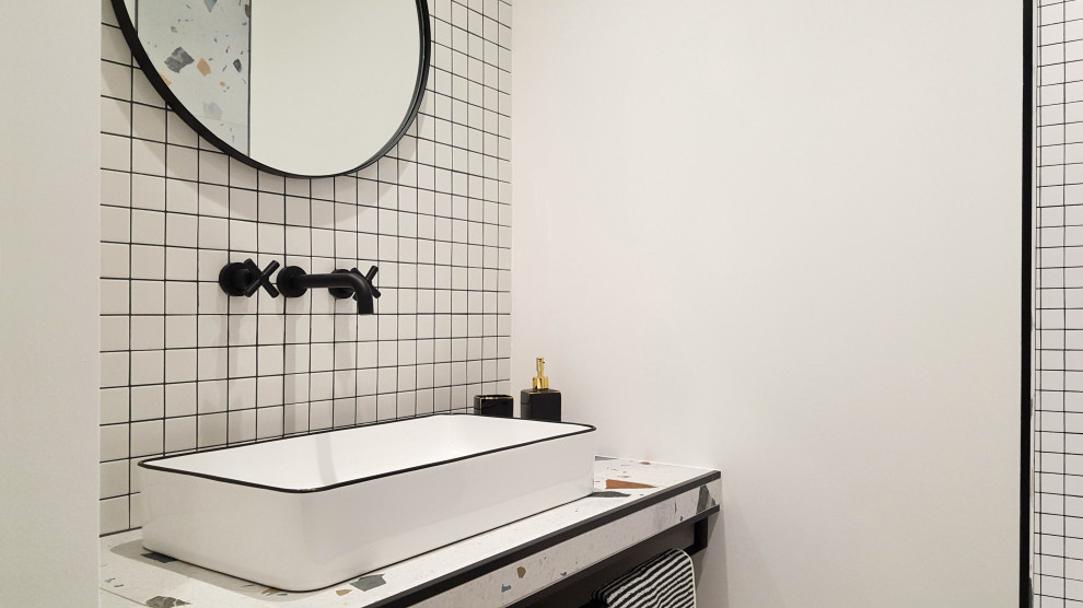 На фото: ванная комната среднего размера со стиральной машиной в стиле фьюжн с белыми фасадами, душем в нише, белой плиткой, белыми стенами, полом из керамической плитки, душевой кабиной, раковиной с несколькими смесителями, стеклянной столешницей, разноцветным полом, открытым душем и тумбой под одну раковину