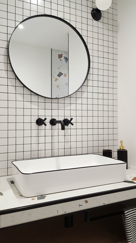 Eklektisk inredning av ett mellanstort badrum med dusch, med vita skåp, en dusch i en alkov, vit kakel, vita väggar, klinkergolv i keramik, ett avlångt handfat, bänkskiva i glas, flerfärgat golv och med dusch som är öppen
