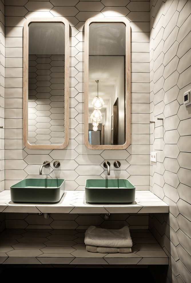 Idéer för ett stort modernt badrum med dusch, med en dusch i en alkov, en vägghängd toalettstol, vit kakel, keramikplattor, vita väggar, betonggolv, ett avlångt handfat, kaklad bänkskiva, blått golv och dusch med gångjärnsdörr