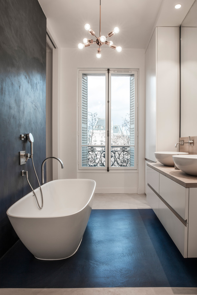Идея дизайна: большая главная ванная комната в современном стиле с белыми фасадами, отдельно стоящей ванной, душем в нише, бежевыми стенами, бетонным полом, раковиной с несколькими смесителями, столешницей из дерева и бежевым полом