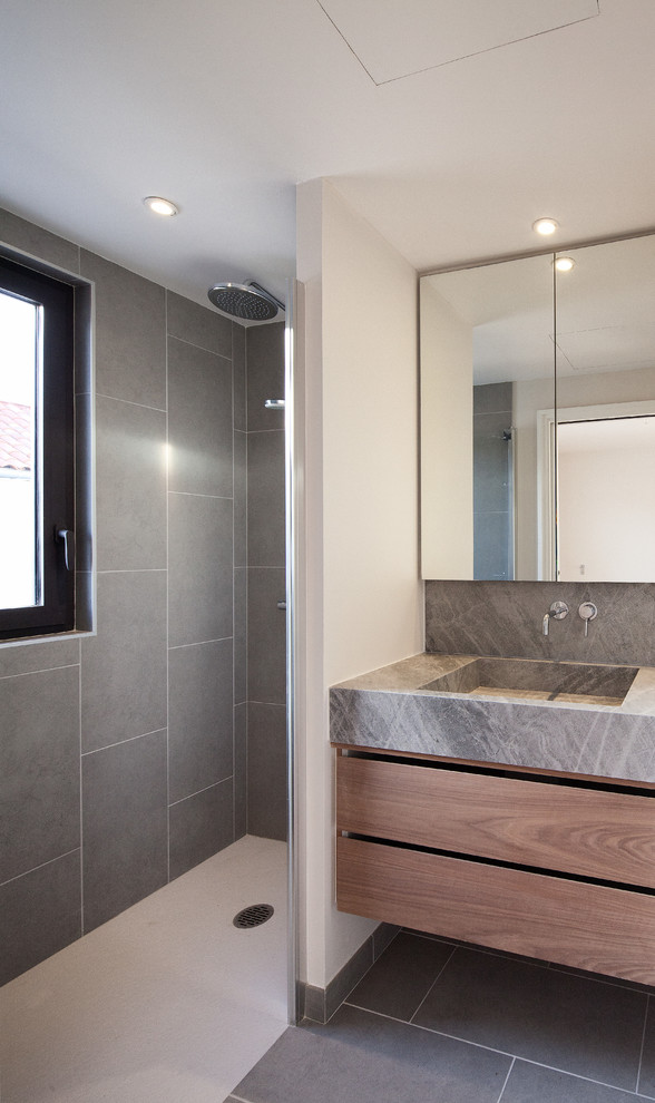 Exempel på ett litet modernt badrum med dusch, med ett konsol handfat, luckor med profilerade fronter, skåp i ljust trä, granitbänkskiva, en dusch i en alkov, grå kakel, keramikplattor, beige väggar och klinkergolv i keramik