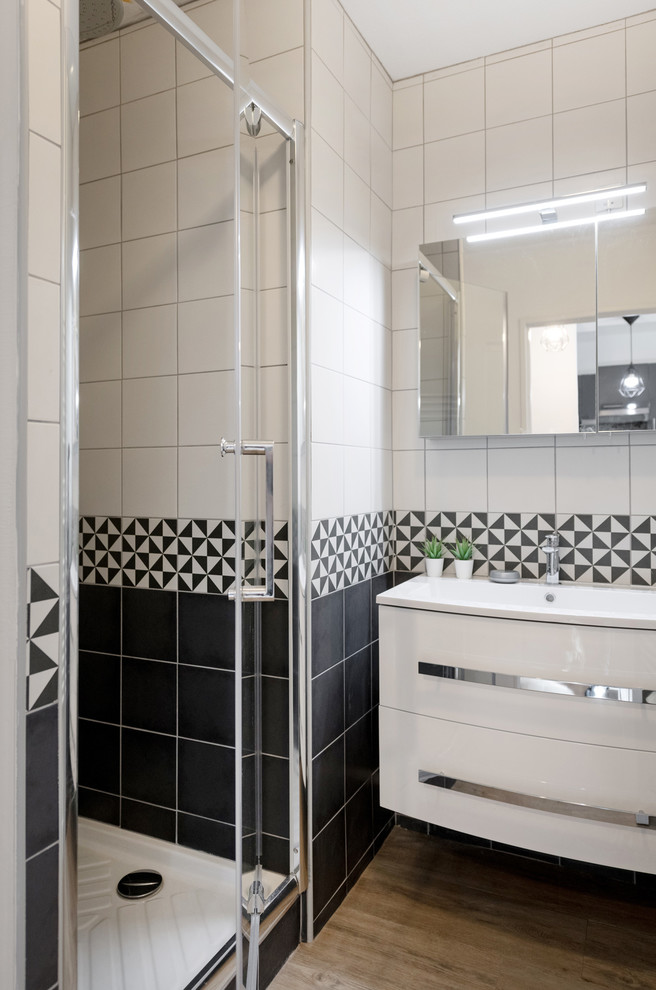 Cette photo montre une petite salle de bain scandinave avec des portes de placard blanches, un carrelage noir et blanc, des carreaux de céramique, un mur noir, un sol en vinyl, un lavabo suspendu, un plan de toilette en surface solide, un sol beige et un plan de toilette noir.