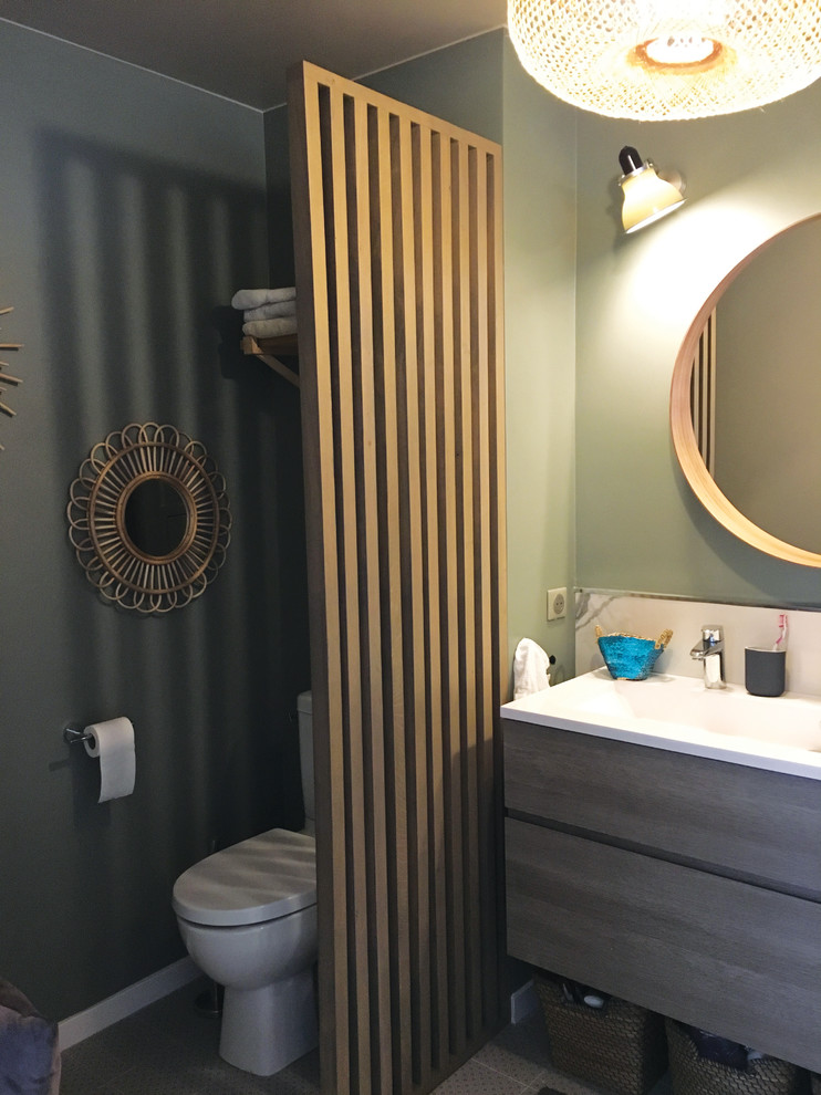 Diseño de cuarto de baño principal bohemio de tamaño medio con lavabo integrado, encimera de laminado, ducha abierta, armarios con paneles lisos, puertas de armario de madera clara, sanitario de una pieza, paredes verdes, encimeras blancas y ducha abierta