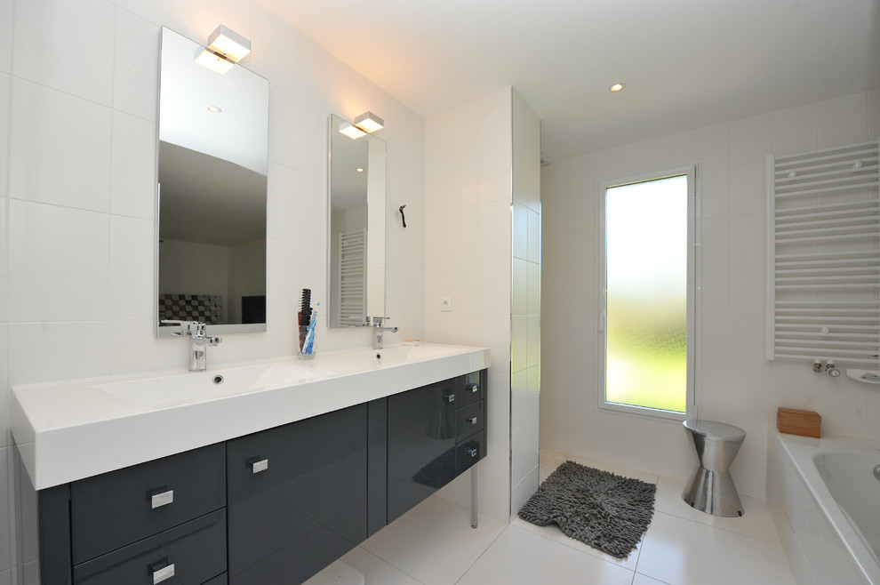 Inspiration pour une salle de bain design avec un placard à porte affleurante, des portes de placard noires, une douche à l'italienne, un carrelage blanc, des carreaux de céramique, un mur blanc, un sol en carrelage de céramique et un lavabo intégré.