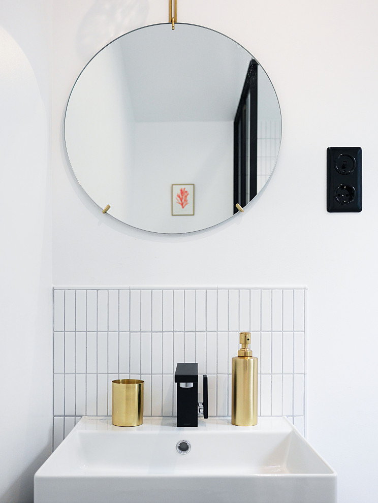 This is an example of a small modern shower room bathroom in Paris with a built-in shower, a wall mounted toilet, white tiles, mosaic tiles, white walls, mosaic tile flooring, a vessel sink, stainless steel worktops, white floors, a shower curtain, black worktops, a single sink and a freestanding vanity unit.