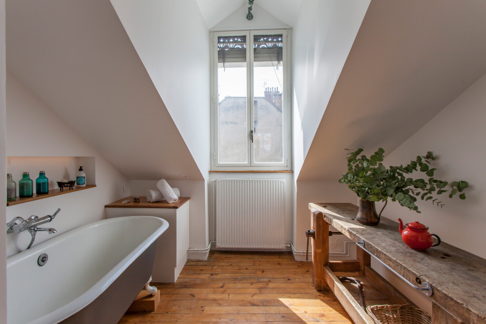 На фото: ванная комната в стиле фьюжн с ванной на ножках, белыми стенами, паркетным полом среднего тона, коричневым полом, нишей и сводчатым потолком с