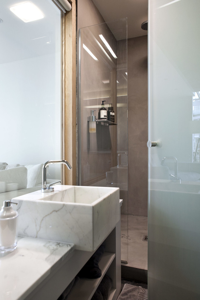 Cette image montre une salle de bain principale et grise et blanche design avec des portes de placard blanches, une douche ouverte, un carrelage gris, un mur gris, un lavabo encastré, un plan de toilette en marbre, un sol gris et meuble simple vasque.