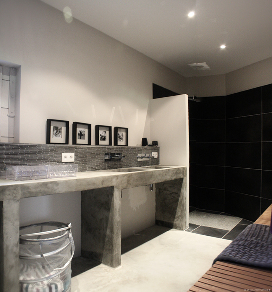 Idéer för ett modernt en-suite badrum, med en kantlös dusch, svart kakel, cementkakel, vita väggar, cementgolv, ett integrerad handfat, beiget golv och med dusch som är öppen