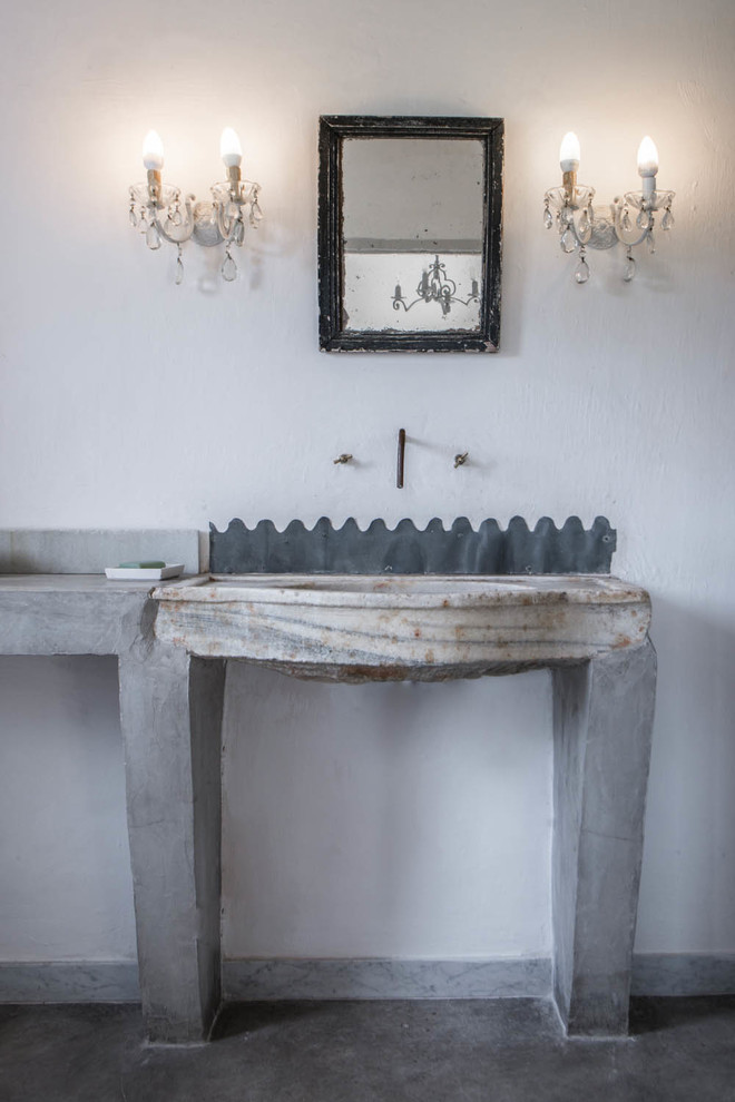 Foto di una stanza da bagno mediterranea con pareti grigie, pavimento in cemento e lavabo a consolle
