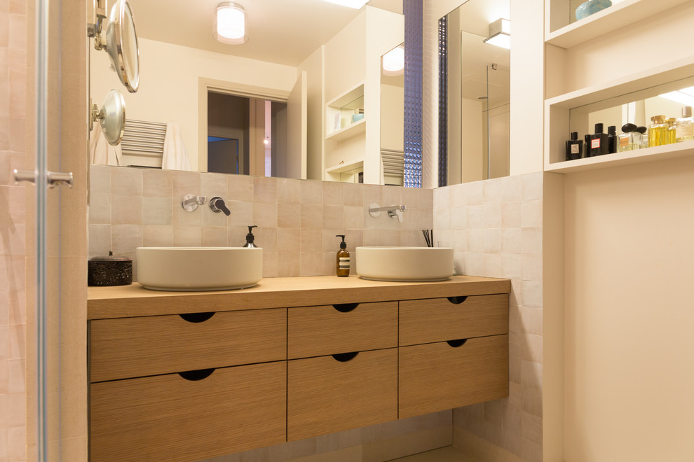 Foto på ett mellanstort funkis badrum, med skåp i ljust trä, vit kakel, perrakottakakel, beige väggar, kalkstensgolv, ett nedsänkt handfat, träbänkskiva och beiget golv