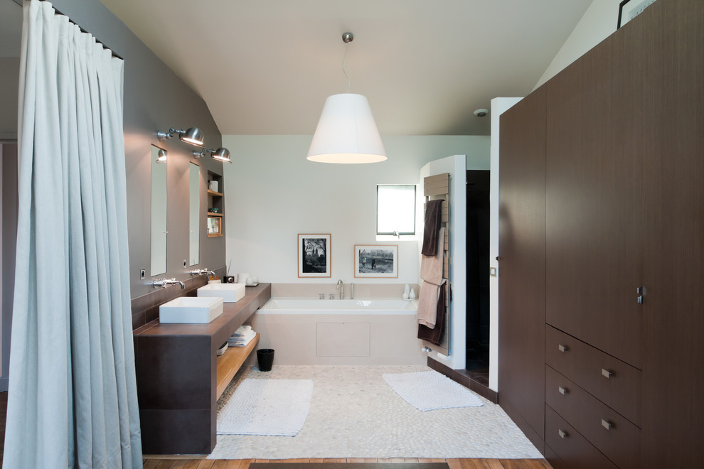 Modernes Badezimmer En Suite mit Aufsatzwaschbecken, flächenbündigen Schrankfronten, dunklen Holzschränken, Badewanne in Nische, Eckdusche, weißer Wandfarbe und Kiesel-Bodenfliesen in Paris