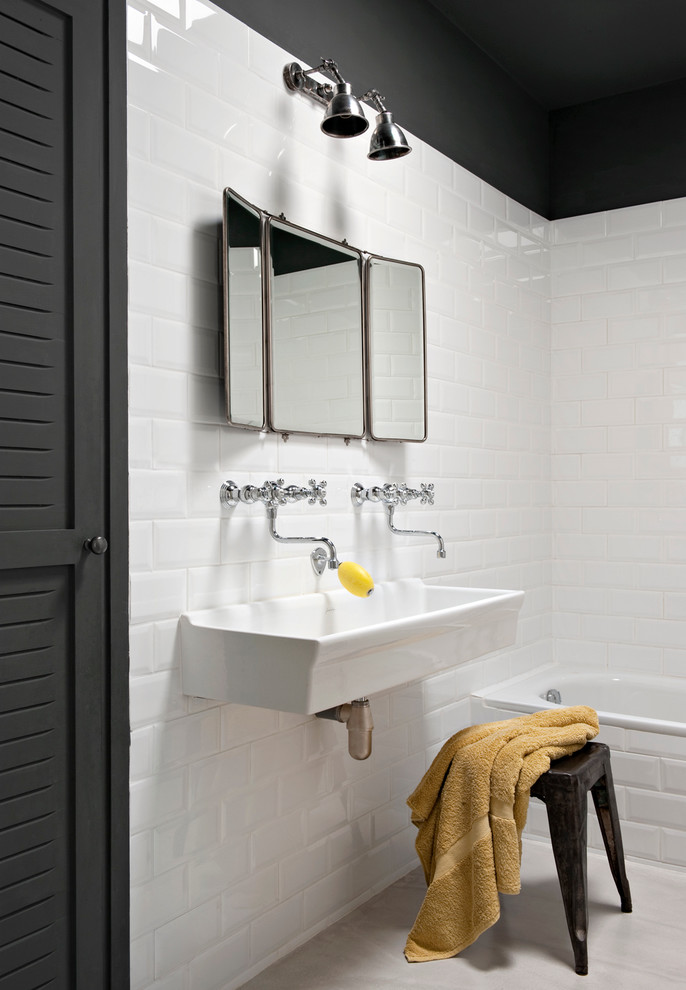 Modelo de cuarto de baño industrial con baldosas y/o azulejos blancos, baldosas y/o azulejos de cemento, lavabo de seno grande, bañera encastrada y paredes blancas