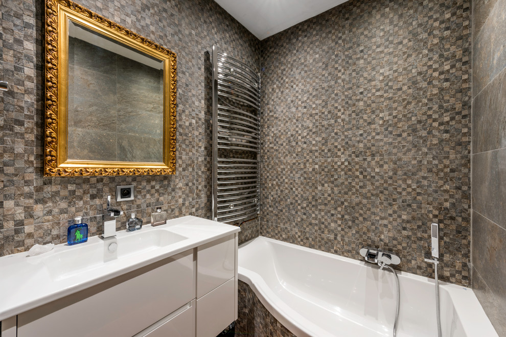 Exemple d'une petite salle de bain principale chic avec des portes de placard blanches, une baignoire posée, un combiné douche/baignoire, un carrelage beige, un carrelage gris et un lavabo intégré.