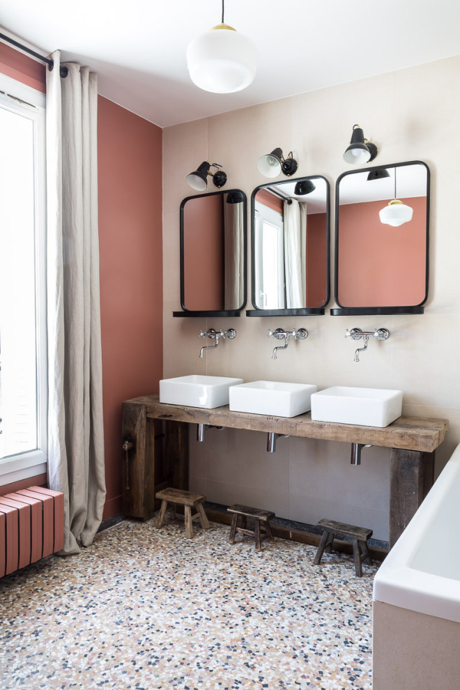 Cette photo montre une salle de bain scandinave avec un mur rouge, une vasque, un plan de toilette en bois, un sol multicolore, un plan de toilette marron et meuble double vasque.