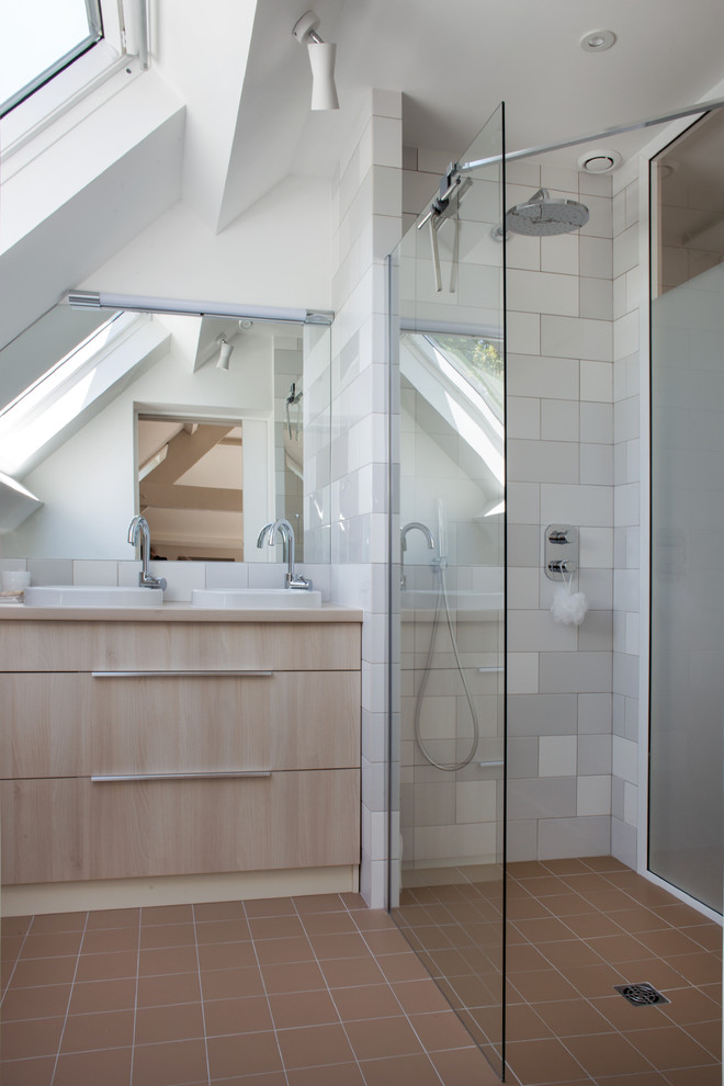 Foto på ett litet skandinaviskt en-suite badrum, med beige skåp, en kantlös dusch, grå kakel, keramikplattor, vita väggar, klinkergolv i terrakotta, ett fristående handfat och brunt golv