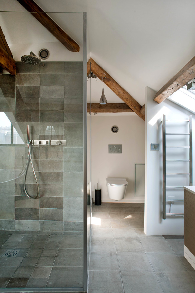 Idée de décoration pour une grande salle d'eau grise et blanche design avec WC suspendus, un carrelage gris, des carreaux de béton, un mur blanc et sol en béton ciré.