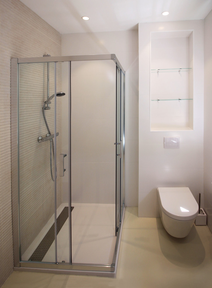 Cette photo montre une petite salle d'eau tendance avec une douche d'angle, WC suspendus, un carrelage beige, des carreaux de céramique, un mur blanc, un sol beige et une cabine de douche à porte coulissante.