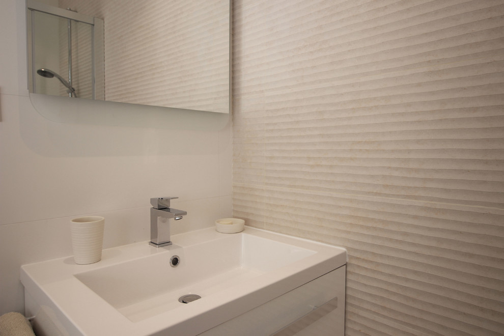 Exempel på ett litet modernt badrum med dusch, med en hörndusch, en vägghängd toalettstol, beige kakel, keramikplattor, vita väggar, beiget golv och dusch med skjutdörr