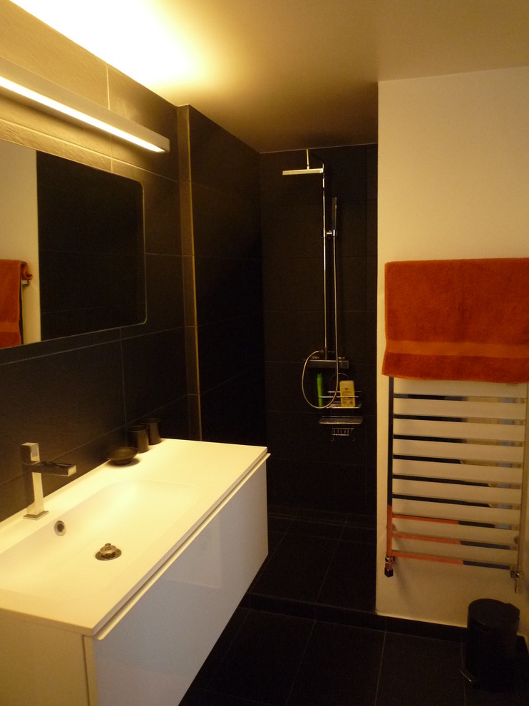 パリにある小さなモダンスタイルのおしゃれなバスルーム (浴槽なし) (壁付け型シンク、人工大理石カウンター、バリアフリー、黒いタイル、セラミックタイル、黒い壁、スレートの床) の写真