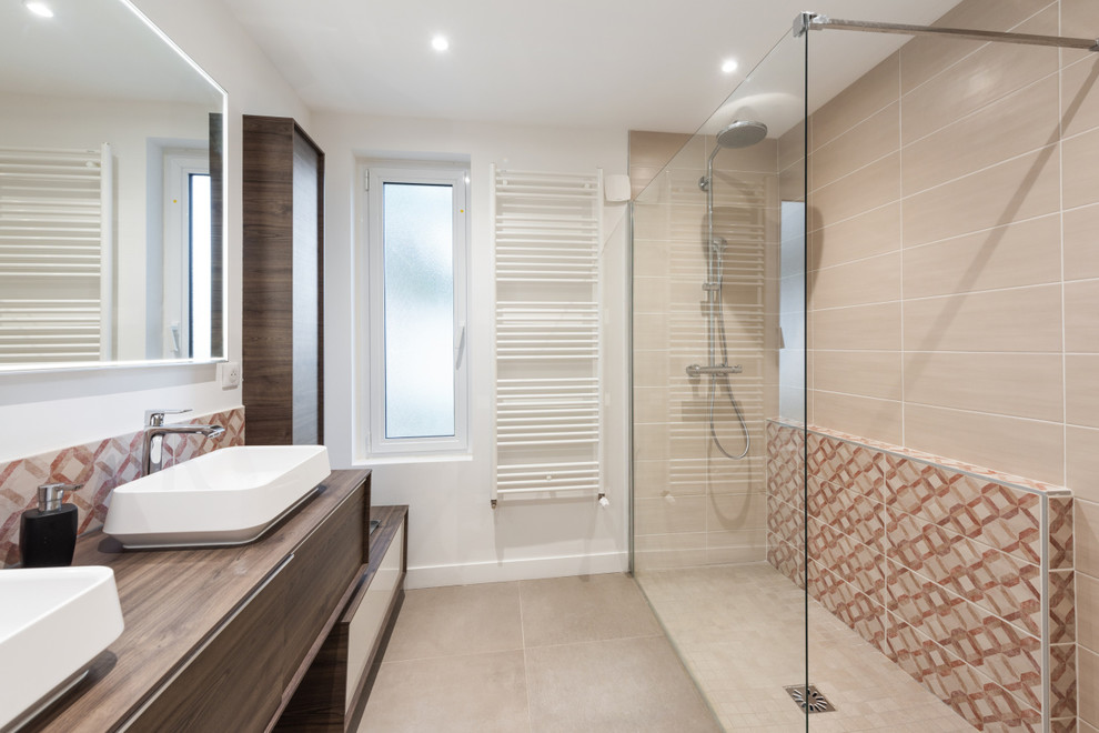 This is an example of a medium sized contemporary ensuite bathroom in Lyon with a built-in shower, beige tiles, ceramic tiles, a built-in sink, wooden worktops, flat-panel cabinets, brown cabinets, brown walls, travertine flooring, beige floors and brown worktops.