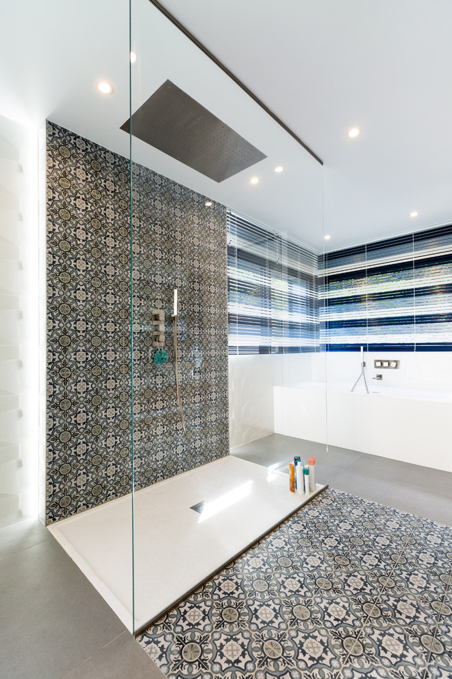 Immagine di una grande stanza da bagno padronale minimal con vasca idromassaggio, doccia aperta, piastrelle blu, piastrelle di cemento, pareti bianche, pavimento con piastrelle in ceramica e pavimento grigio