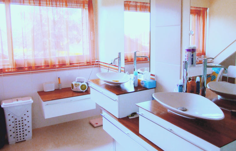 Esempio di una stanza da bagno con doccia design di medie dimensioni con vasca freestanding, vasca/doccia, piastrelle bianche, piastrelle in ceramica, pareti bianche, pavimento in vinile, lavabo da incasso, top in legno, pavimento bianco e top marrone