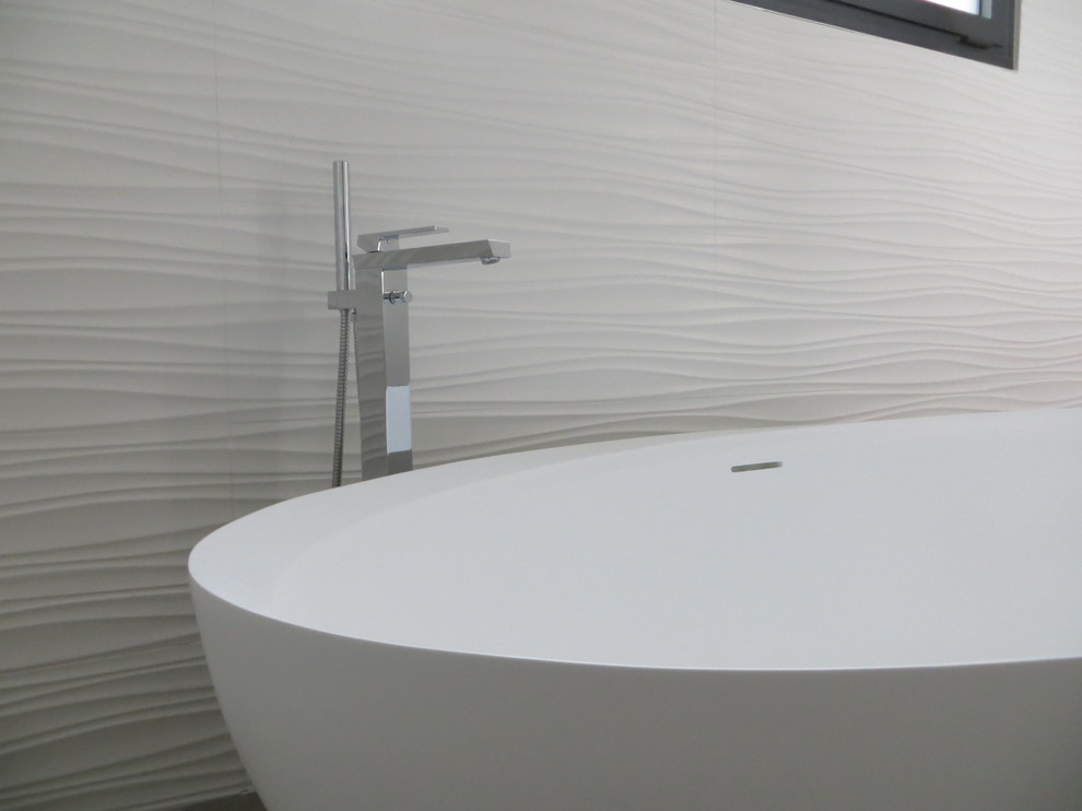 Idéer för att renovera ett stort funkis vit vitt en-suite badrum, med luckor med upphöjd panel, vita skåp, ett platsbyggt badkar, en kantlös dusch, en vägghängd toalettstol, vit kakel, keramikplattor, vita väggar, klinkergolv i keramik, ett konsol handfat, bänkskiva i akrylsten, grått golv och med dusch som är öppen