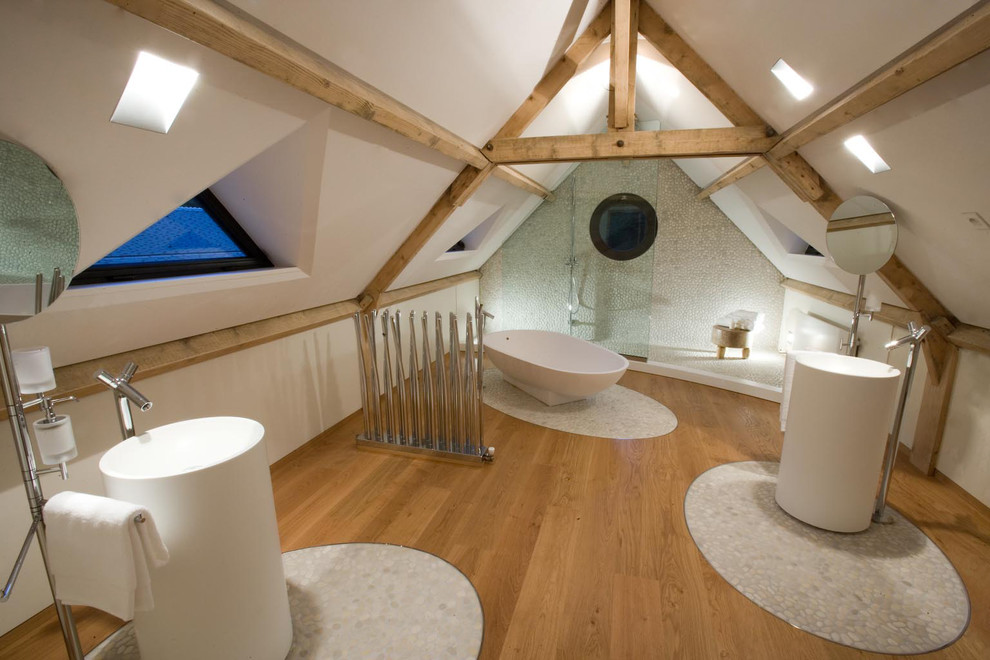 Large contemporary ensuite bathroom in Paris with pebble tile flooring, a freestanding bath, white walls and an open shower.