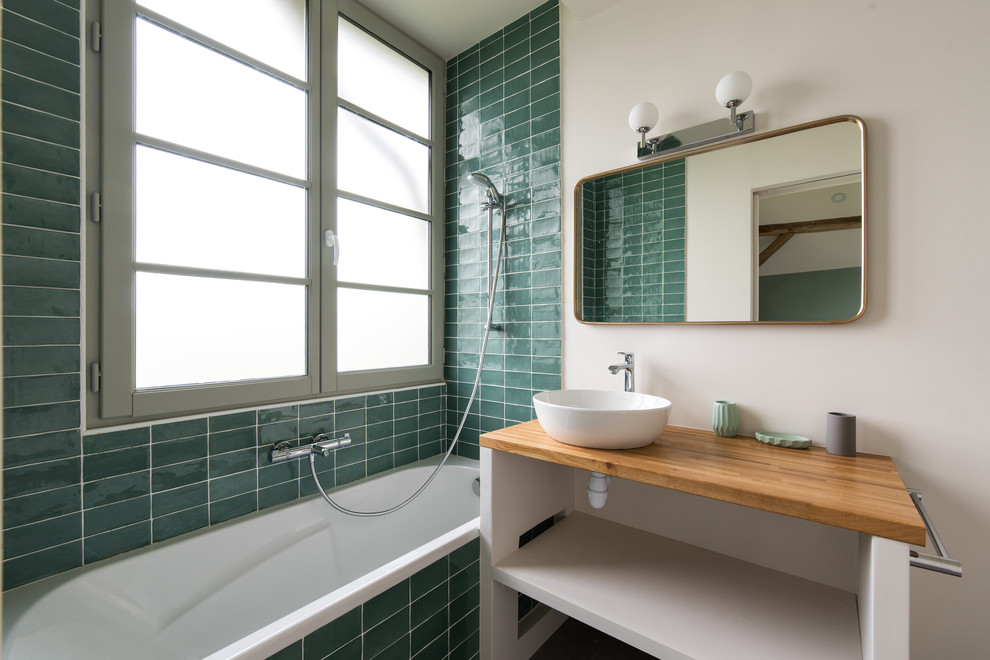 Inspiration pour une salle de bain rustique de taille moyenne avec des portes de placard blanches, une baignoire en alcôve, un combiné douche/baignoire, un carrelage vert, un mur blanc, une vasque, un plan de toilette en bois, un plan de toilette marron et un placard sans porte.