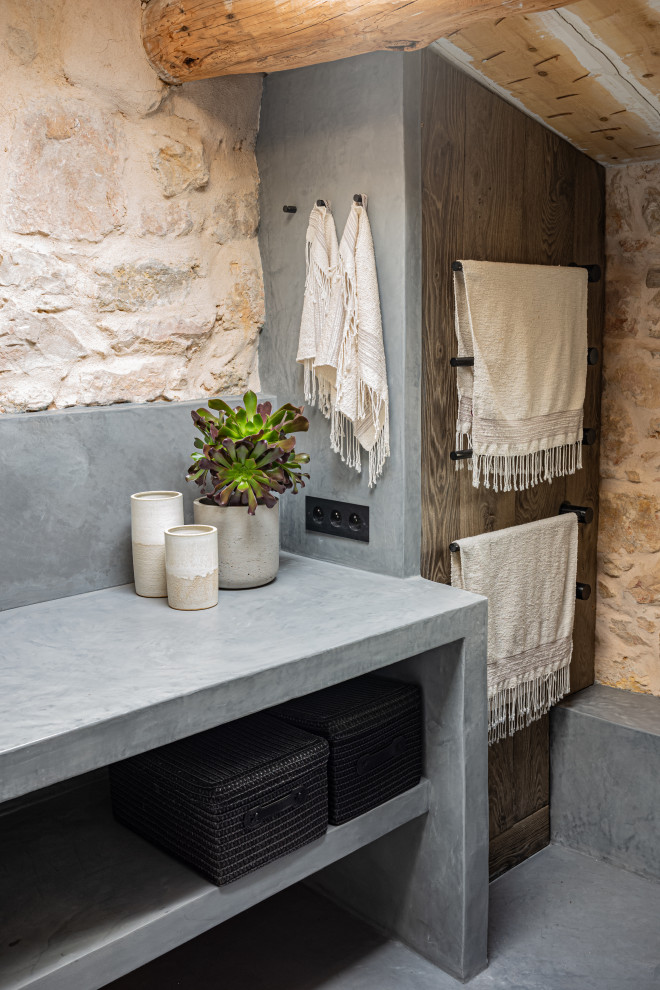 Medium sized mediterranean ensuite bathroom in Nice with open cabinets, medium wood cabinets, a built-in shower, a wall mounted toilet, grey tiles, beige walls, concrete flooring, a built-in sink, concrete worktops, grey floors, an open shower and grey worktops.