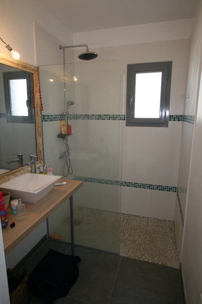 Inredning av ett modernt mellanstort badrum med dusch, med skåp i ljust trä, laminatbänkskiva, svart kakel, mosaik, en kantlös dusch, ett nedsänkt handfat, vita väggar och skiffergolv