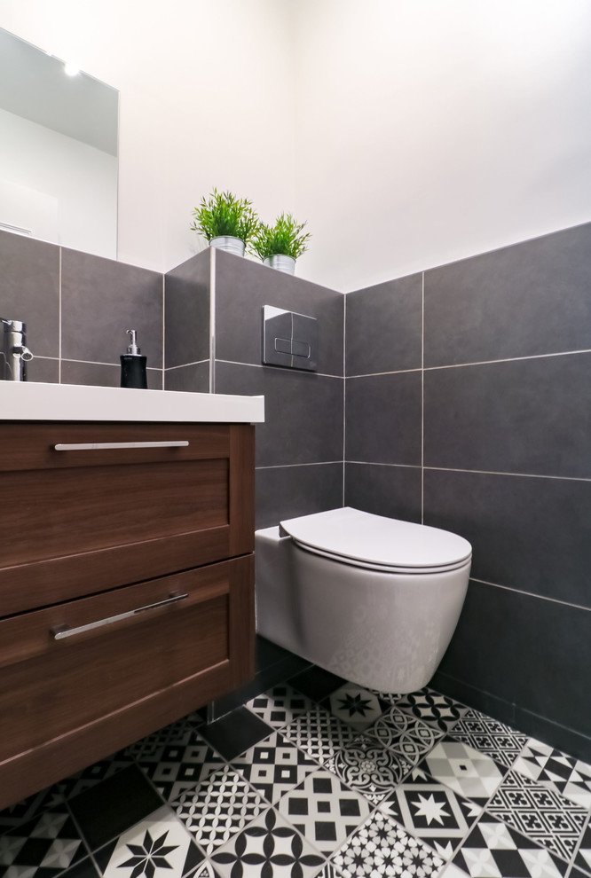 Cette photo montre une petite salle de bain principale tendance en bois brun avec un placard à porte affleurante, WC suspendus, un carrelage noir, des carreaux de céramique, un mur blanc, un sol en linoléum, un lavabo suspendu et un sol noir.