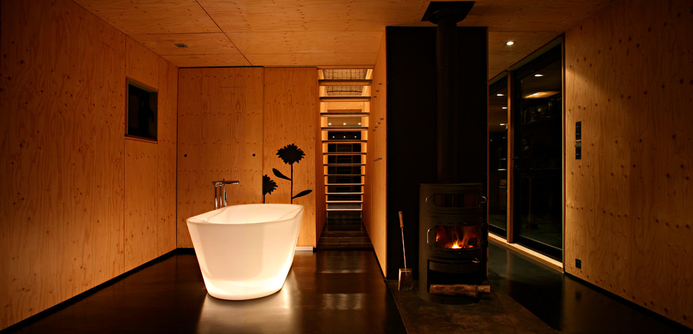 Large trendy master black floor freestanding bathtub photo in Paris with medium tone wood cabinets