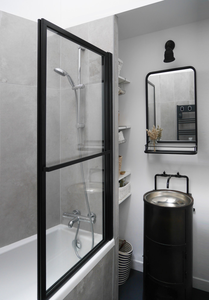 Bild på ett litet industriellt svart svart en-suite badrum, med öppna hyllor, vita skåp, ett platsbyggt badkar, grå kakel, keramikplattor, vita väggar, betonggolv, ett nedsänkt handfat, bänkskiva i rostfritt stål och grått golv