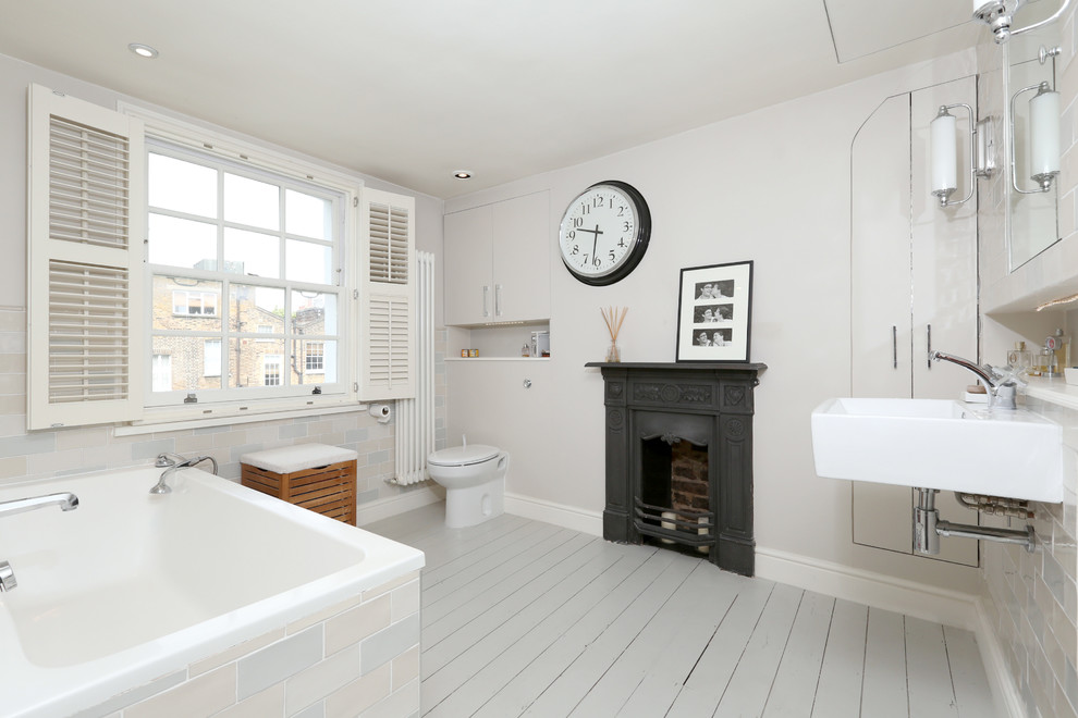 Свежая идея для дизайна: ванная комната среднего размера в викторианском стиле с полновстраиваемой ванной, бежевой плиткой, удлиненной плиткой, бежевыми стенами, деревянным полом и подвесной раковиной - отличное фото интерьера