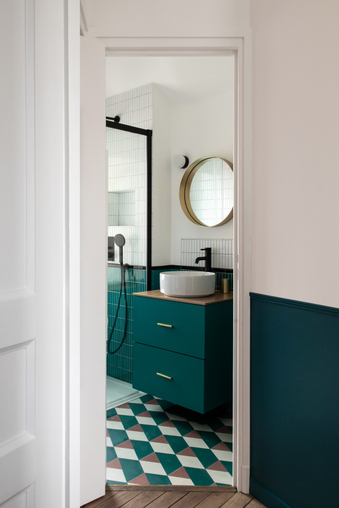Inredning av ett modernt litet beige beige badrum med dusch, med släta luckor, blå skåp, en kantlös dusch, vit kakel, keramikplattor, vita väggar, cementgolv, ett fristående handfat, träbänkskiva, blått golv och dusch med skjutdörr