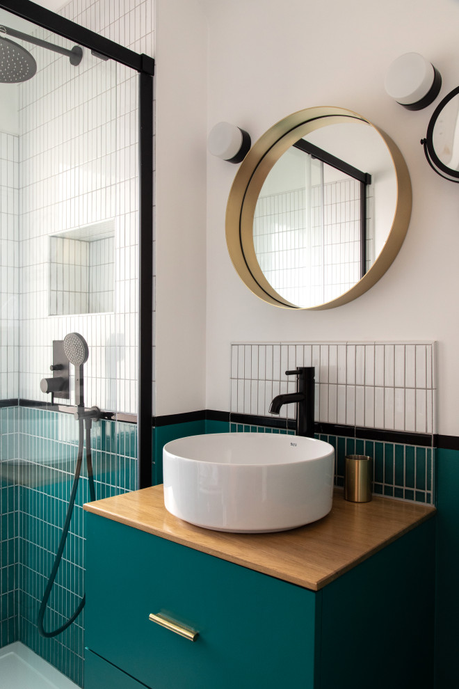 Inspiration för små moderna beige badrum med dusch, med släta luckor, blå skåp, en kantlös dusch, vit kakel, keramikplattor, vita väggar, cementgolv, ett fristående handfat, träbänkskiva, blått golv och dusch med skjutdörr