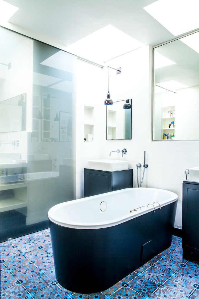 Inspiration pour une salle de bain principale bohème de taille moyenne avec des portes de placard noires, une baignoire indépendante, un carrelage multicolore, un carrelage bleu, un mur blanc, une vasque et un sol en carrelage de céramique.