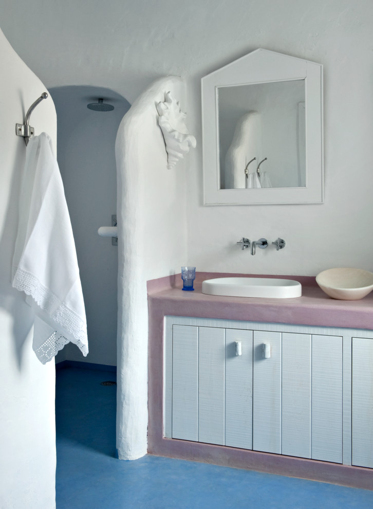 他の地域にある中くらいなビーチスタイルのおしゃれなマスターバスルーム (白いキャビネット、アルコーブ型シャワー、白い壁、コンクリートの床、オーバーカウンターシンク) の写真