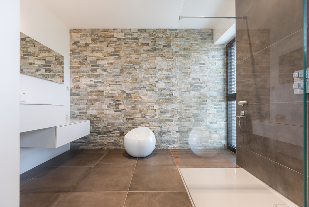 Inspiration pour une salle d'eau minimaliste de taille moyenne avec un placard à porte affleurante, des portes de placard blanches, une douche à l'italienne, un carrelage gris, du carrelage en pierre calcaire, un mur beige, un sol en carrelage de céramique, un lavabo suspendu et un sol gris.