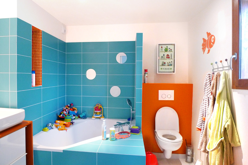 Mittelgroßes Modernes Kinderbad mit Eckbadewanne, Wandtoilette, blauen Fliesen, Keramikfliesen, Aufsatzwaschbecken, Waschtisch aus Holz und weißer Wandfarbe in Paris